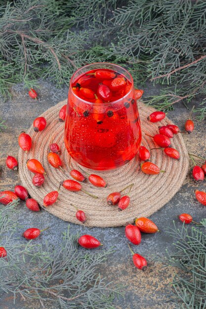 Um copo de suco vermelho sobre fundo de mármore. Foto de alta qualidade