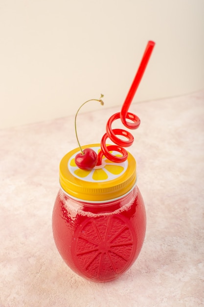 Um coquetel de cereja vermelha fresca e cobertura com canudo na mesa rosa beber suco cor de frutas