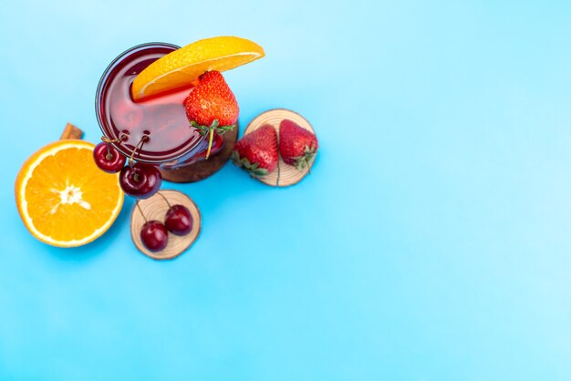 Um coquetel de frutas frescas com fatias de frutas frescas esfriando no azul, beba um coquetel de frutas frescas