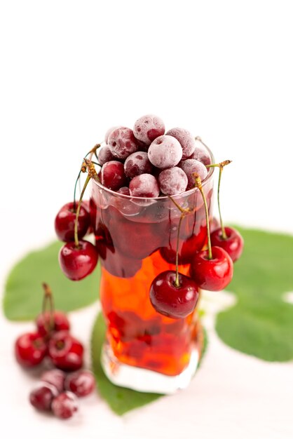 Um coquetel de frutas frescas com gelo de cerejas vermelhas frescas resfriando no branco, beba um coquetel de frutas coloridas