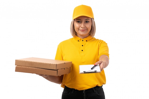 Um correio feminino vista frontal na camisa amarela boné amarelo segurando caixas e papel sorrindo em branco