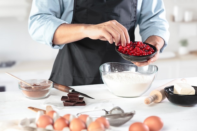 Foto grátis um cozinheiro com ovos em uma cozinha rústica contra a parede das mãos dos homens