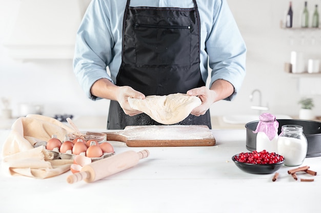 Um cozinheiro com ovos em uma cozinha rústica contra a parede das mãos dos homens