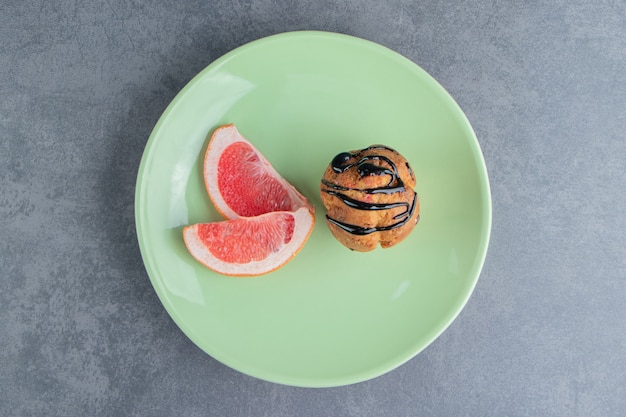 Um cupcake de chocolate com rodelas de toranja