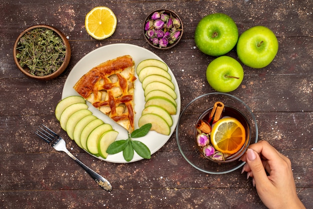 Foto grátis um delicioso bolo de maçã com chá de maçã verde fresca e limão na mesa de madeira