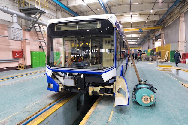 Um dia útil de fabricação de ônibus automático moderno com trabalhadores de carros inacabados na produção de automóveis uniformes de proteção