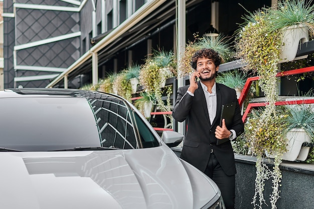 Foto grátis um empresário passa por seu carro