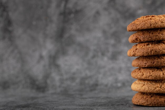 Um estoque de biscoitos de aveia em concreto cinza.