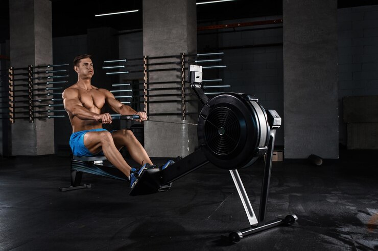 Foto grátis um fisiculturista a trabalhar nas pernas com uma máquina de pesos no ginásio. um jovem musculoso com calções azuis a fazer exercícios.