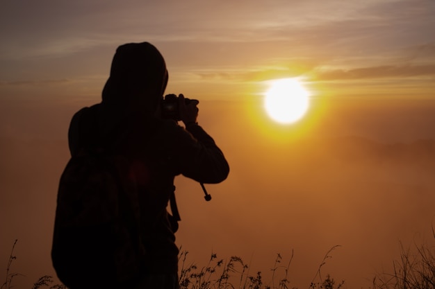 Um fotógrafo fotografa o amanhecer do sol no vulcão Batur. Bali, Indonésia