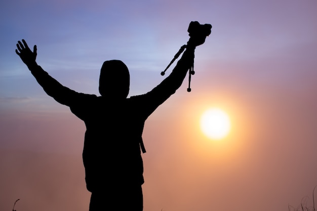 Um fotógrafo fotografa o amanhecer do sol no vulcão Batur. Bali, Indonésia