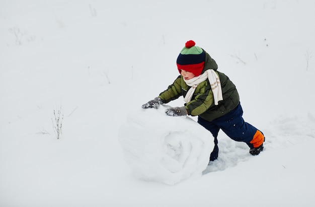 Um garotinho cria um boneco de neve