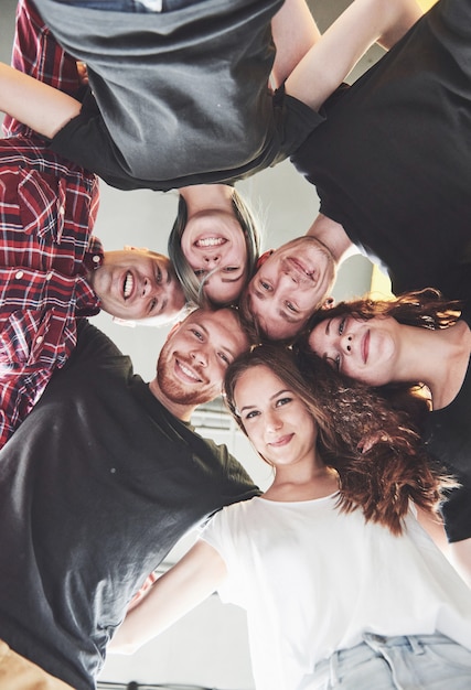 Um grande grupo de amigos sorridentes abraçando juntos.