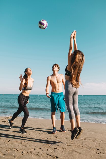 Um grupo de amigos a jogar voleibol na praia.