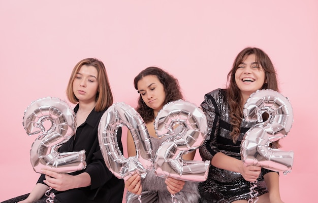 Um grupo de meninas com balões de papel alumínio na forma de números