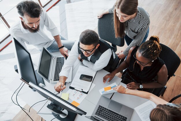 Um grupo de pessoas multinacionais ocupadas trabalhando no escritório.