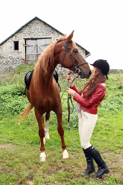 Um hipismo feminino com um cavalo marrom