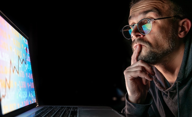 Foto grátis um homem analisando dados financeiros de gráficos do mercado de ações em uma placa eletrônica