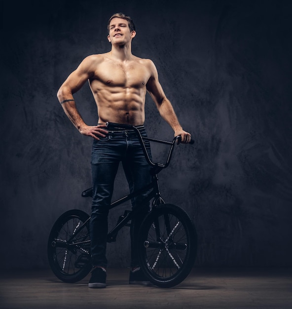 Um homem bonito com BMX em um estúdio.