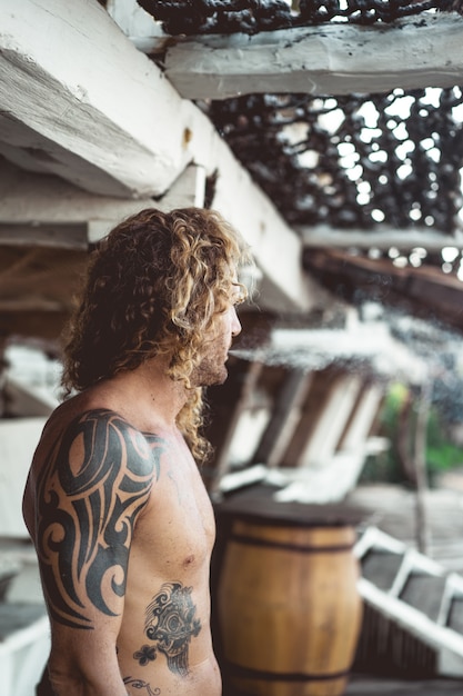 Foto grátis um homem com cabelo longo encaracolado em um local de pesca. pescador no oceano