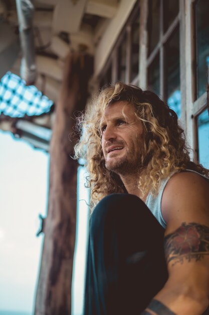 um homem com cabelo longo encaracolado em um local de pesca. pescador no oceano