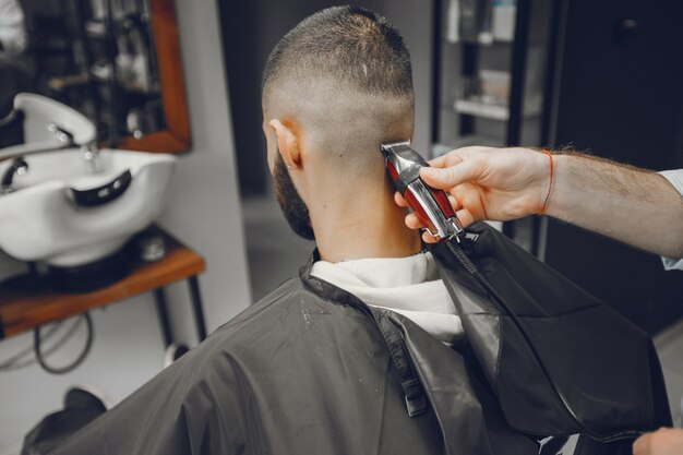 Um homem corta o cabelo em uma barbearia.