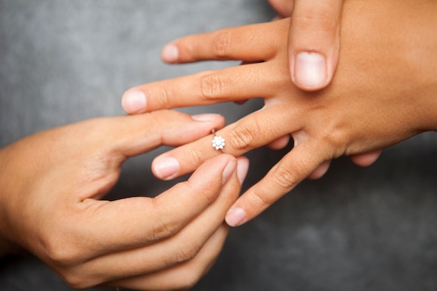Um homem dando a uma mulher um anel de casamento. Conceito de proposta de casamento