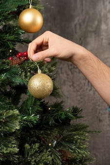 Um homem decorando a árvore de natal.