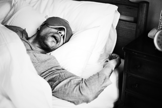 Um homem dormindo em uma cama