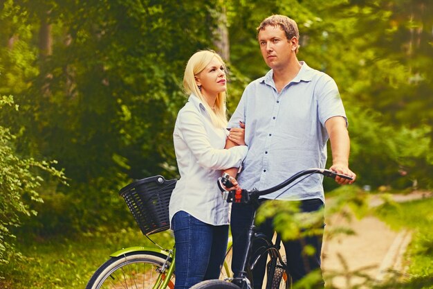 Um homem e uma mulher em um passeio de bicicleta em um parque selvagem.