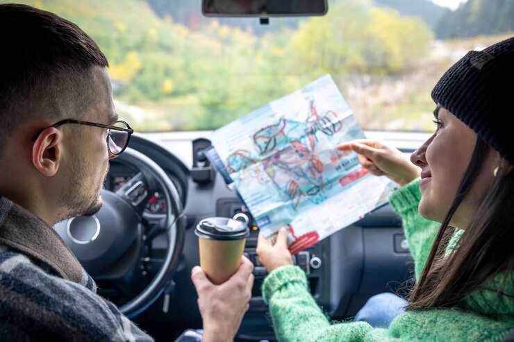 Foto grátis um homem e uma senhora segurando e olhando para o mapa de papel sentado dentro do carro