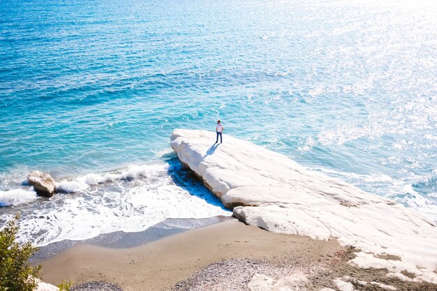 Um homem em pé na costa de um mar