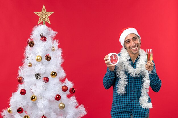 Um homem está parado ao lado da árvore de natal