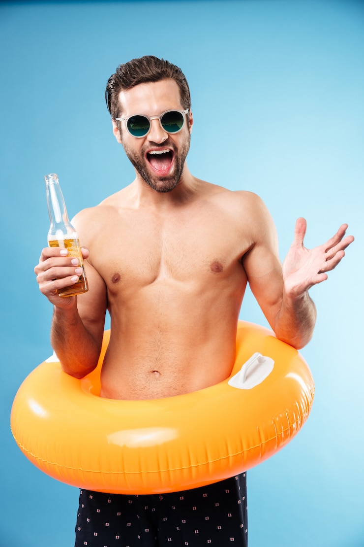 Foto grátis um homem feliz, sorridente, sem camisa, usando um anel inflável.