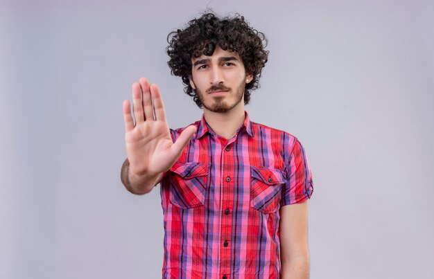 Um homem sério e bonito com cabelo encaracolado e camisa xadrez de mãos dadas ou gesto suficiente