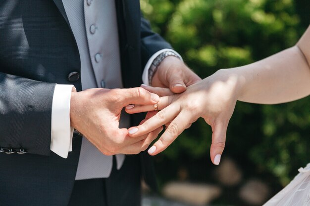 Um homem usa um anel de casamento para sua esposa