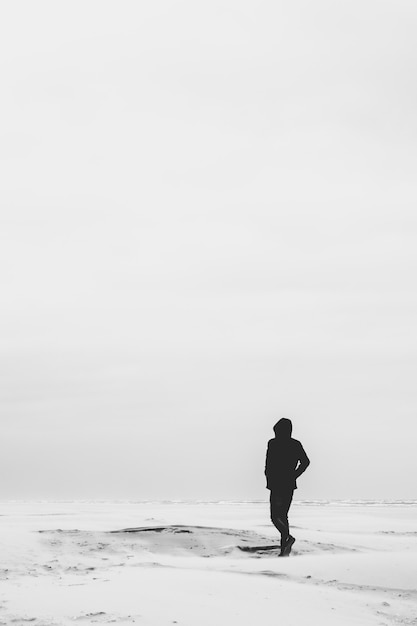 Um homem vestido de preto andando em uma superfície branca lisa