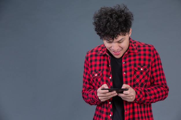Um homem vestindo uma camisa xadrez vermelha com um smartphone