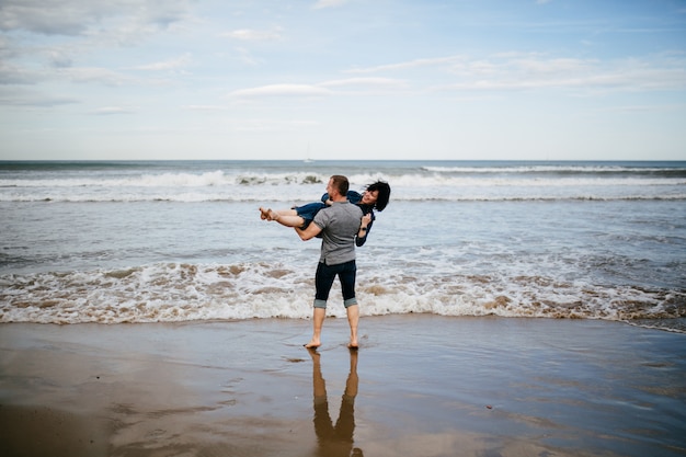 Um jovem casal caminhando na praia