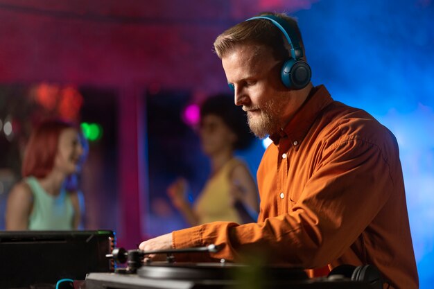 Um jovem DJ de médio nível numa festa de techno.