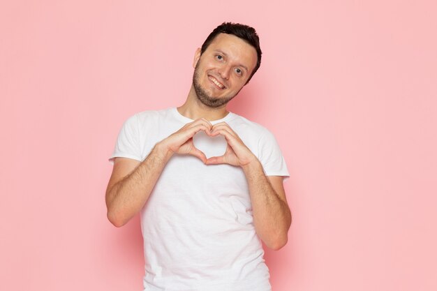 Um jovem do sexo masculino com camiseta branca posando com uma expressão de amor encantado