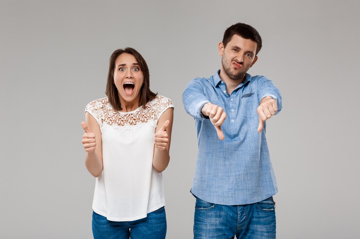Foto grátis um jovem e lindo casal posando sobre uma parede cinzenta.