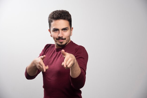 Um jovem moreno em pé e posando.