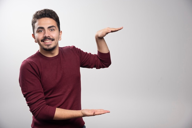 Um jovem moreno em pé e posando.