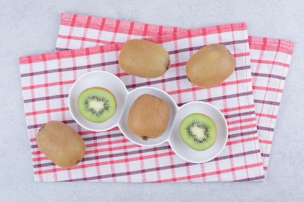 Um kiwi fatiado em chapa branca na toalha de mesa. Foto de alta qualidade