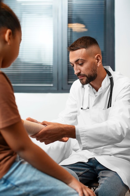 Foto grátis um médico a tomar conta de uma criança afro-americana.