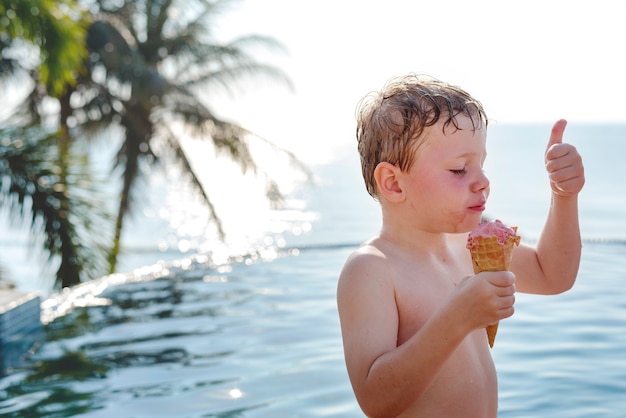 Um menino e um bom sorvete à beira da piscina