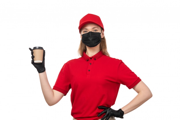 Um mensageiro feminino vista frontal na máscara de camisa vermelha preta segurando a xícara de café