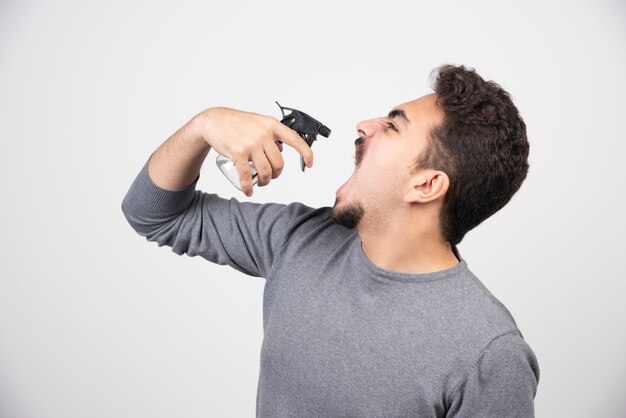 Um modelo de jovem segurando o frasco de spray de plástico.