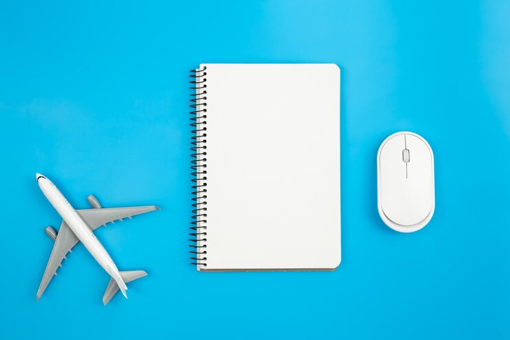 Foto grátis um mouse de computador em miniatura de avião e notebook em plano de fundo azul